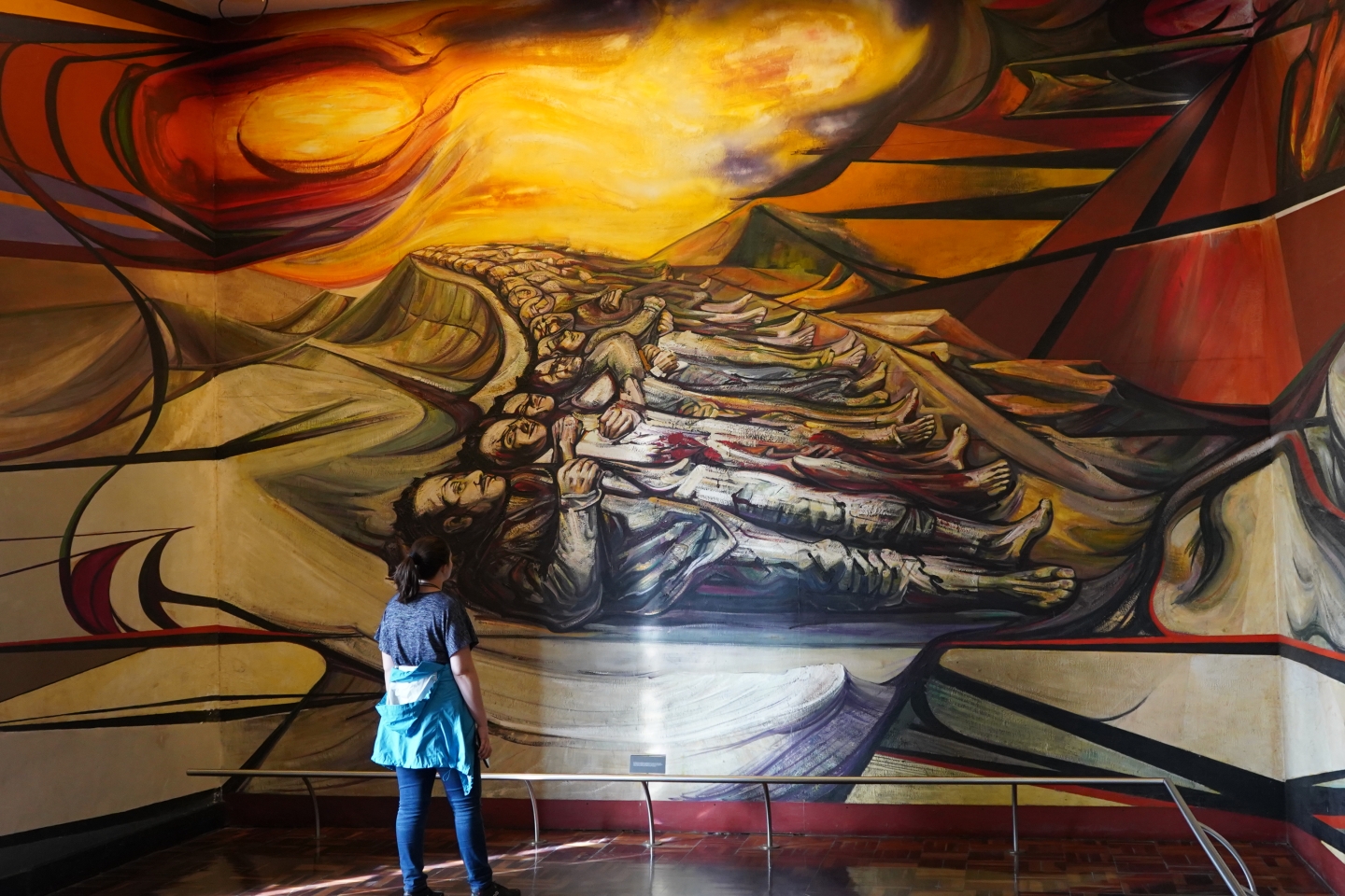 Student gazing at a huge Spanish mural at an exhibit 
