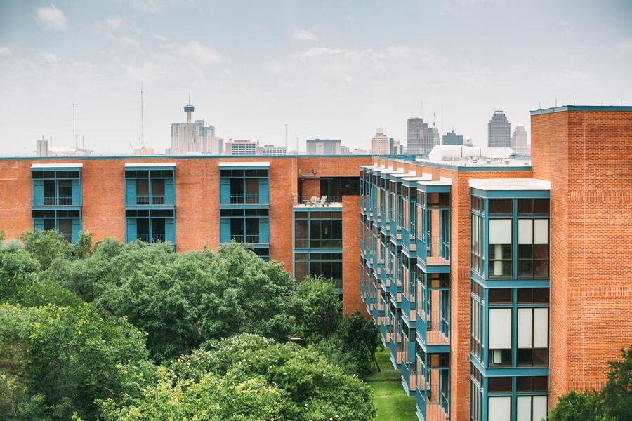 Exterior view of Prassel Hall with San Antonio skyline in the background