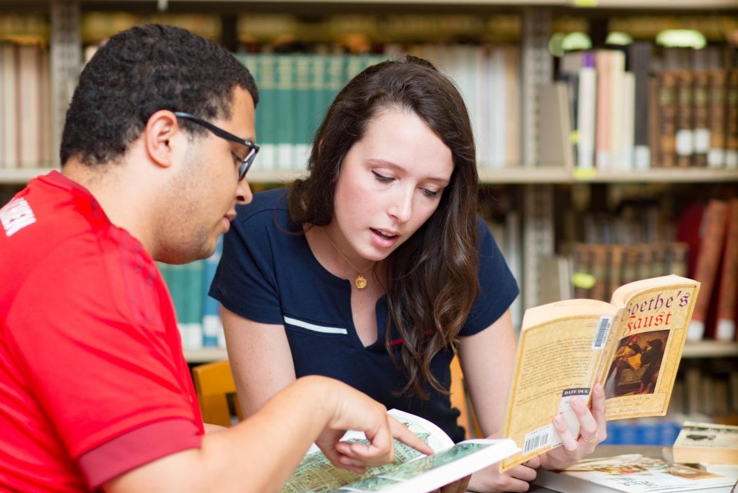 Two students look at map inside of a book