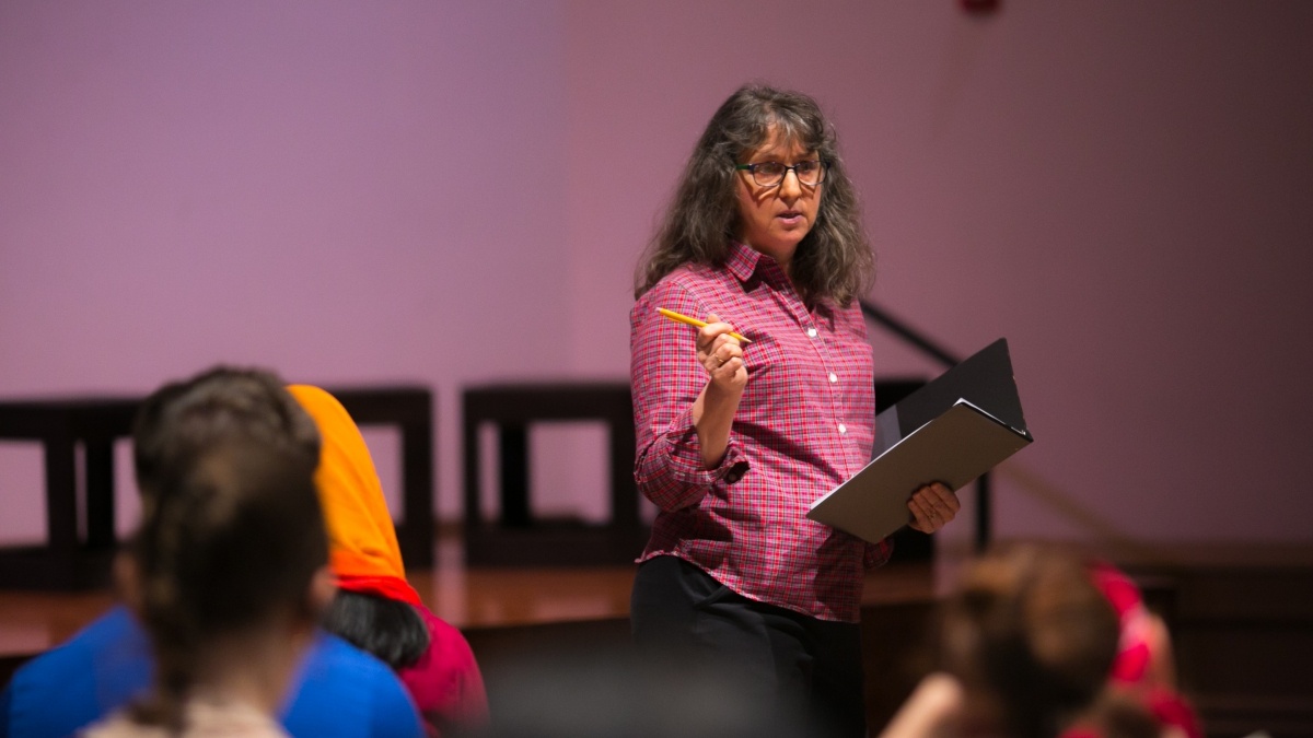 Professor talking to class in front of a stage