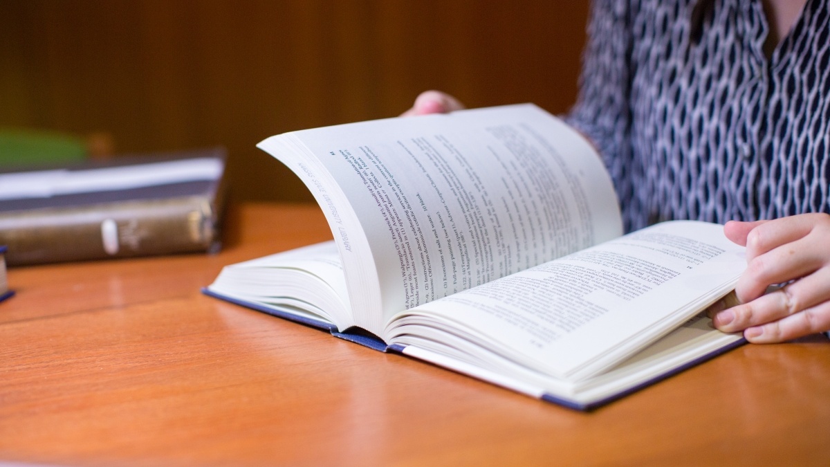 Student with a book open face