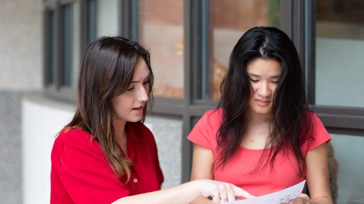 Students look over document together.