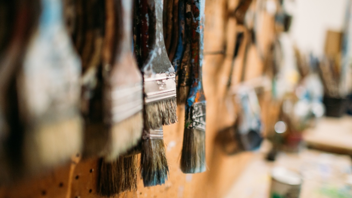 paint brushes hang on a wall in the art studio