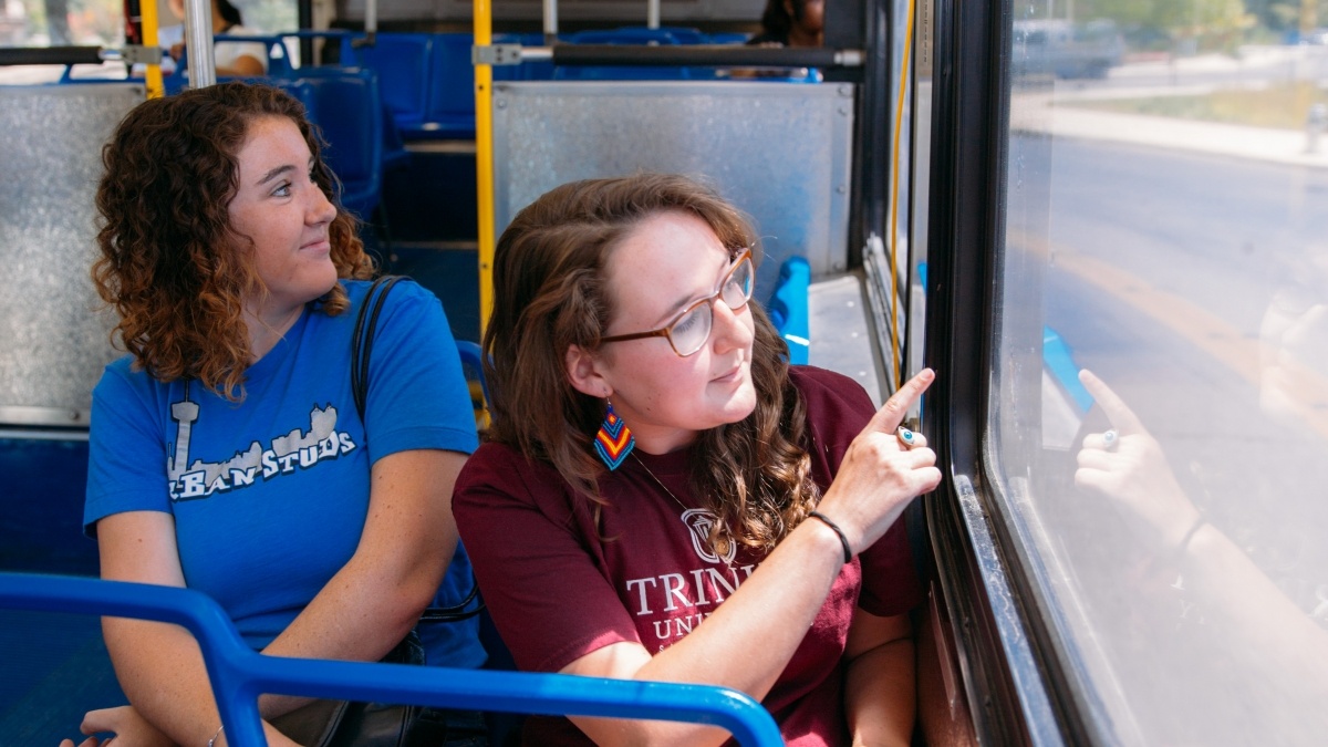 Two students on a bus looking out the window