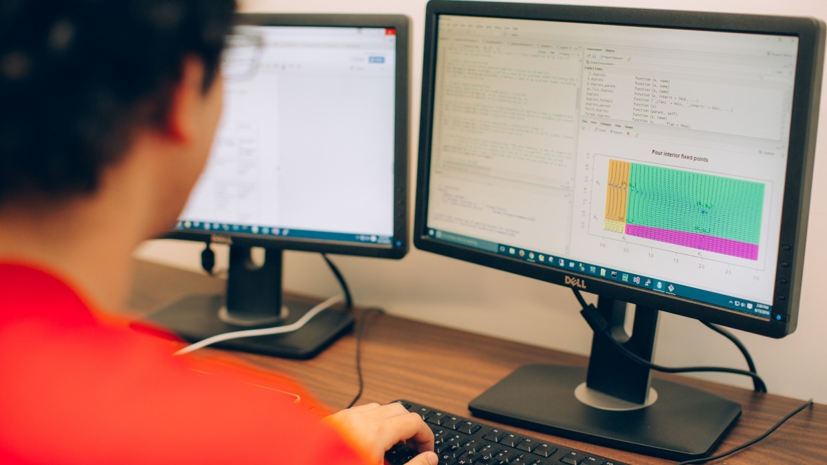 Student looks at code on a computer. 