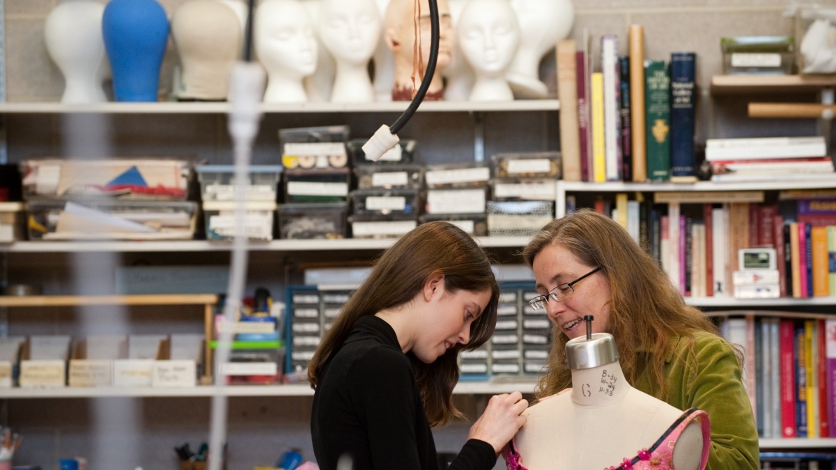 Two women working on a costume.