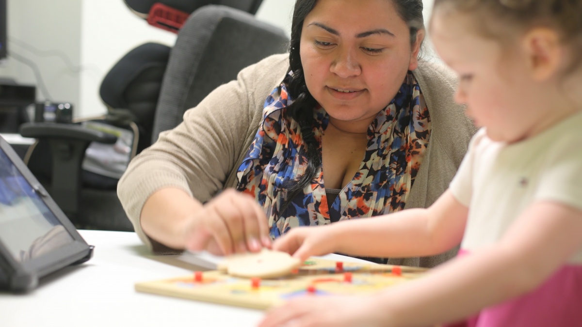 Student with a child working through puzzle